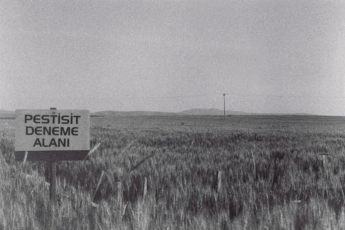 agricultural field with pesticide warning sign