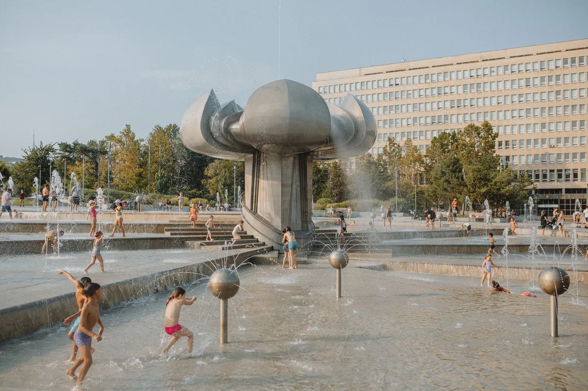people cooling off in public fountain